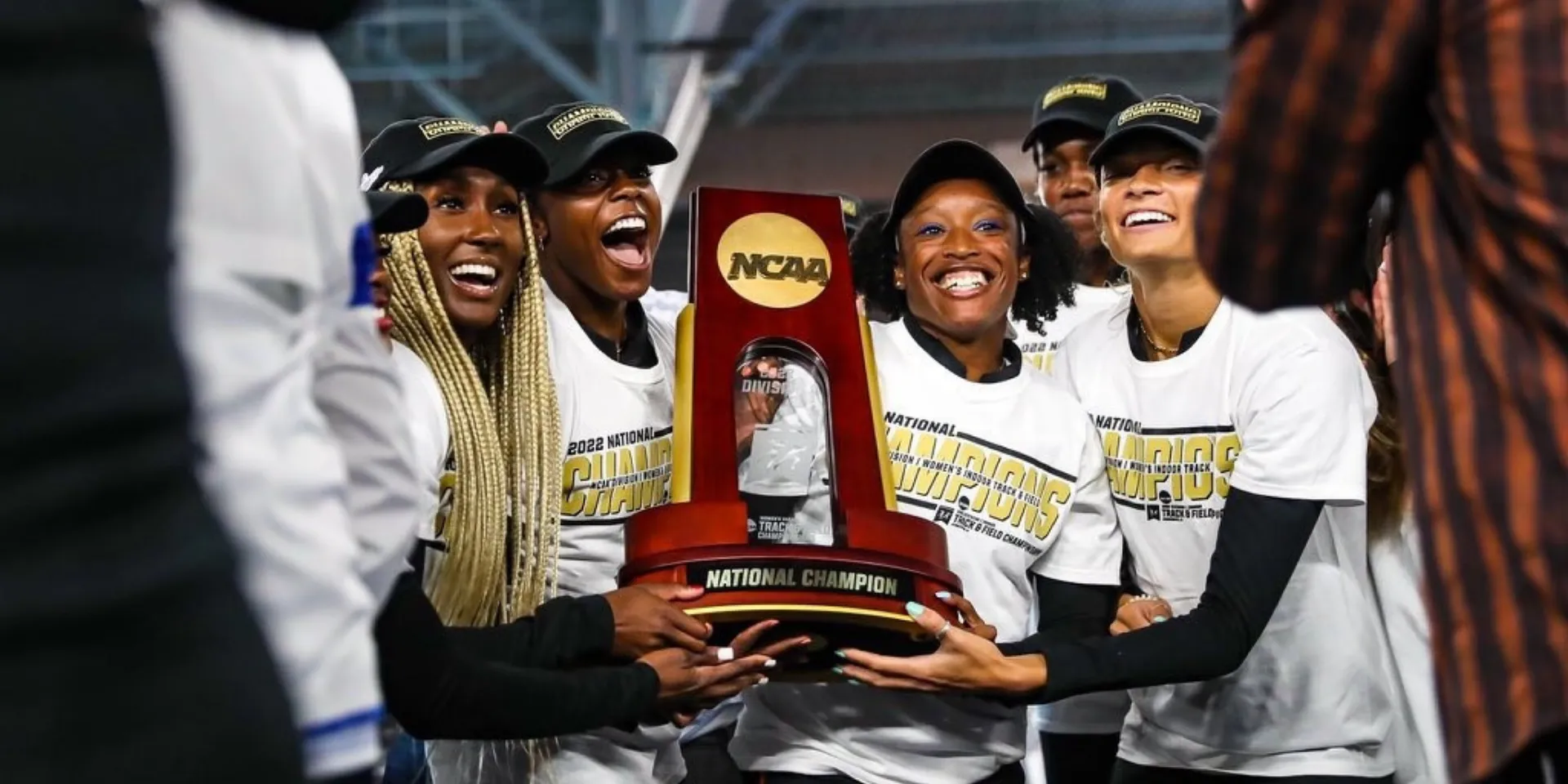 women's team holding NCAA championship trophy
