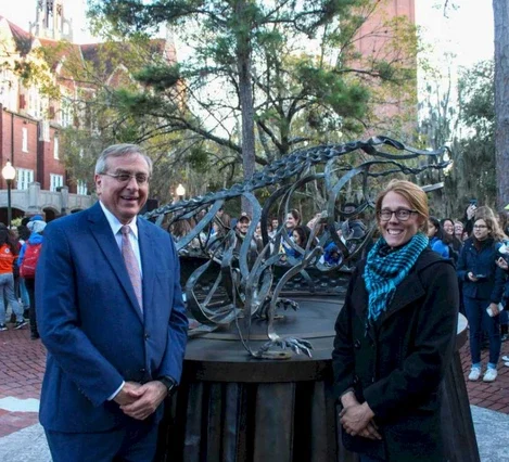 President Fuchs joins artist and UF College of the Arts graduate Leslie Tharp at the unveiling of The Holiday Gator, her forged-steel alligator sculpture commissioned for the first annual “Lighting of the Holiday Gator” in December 2019.