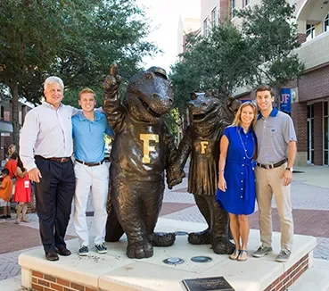cards-alumni-statue alumni standing with gator statue