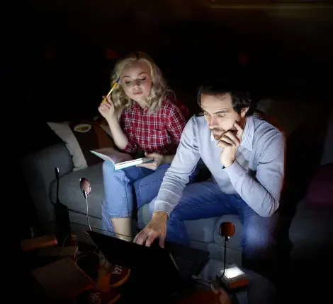 A couple sitting in the dark trying to figure out how to get power back on.