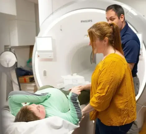 A mother next to her son after a medical scan.