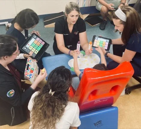 UF students gathered around a seated child.