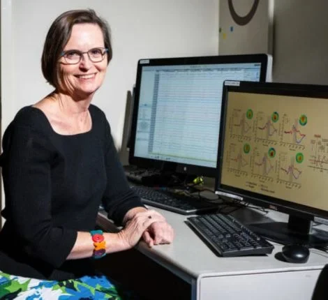 A researcher smiles at her computer.