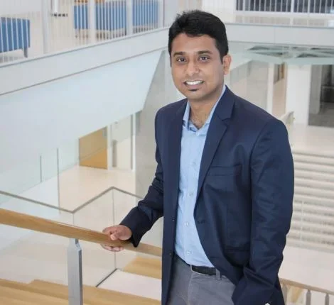 A researcher stands in front of steps at UF's campus.