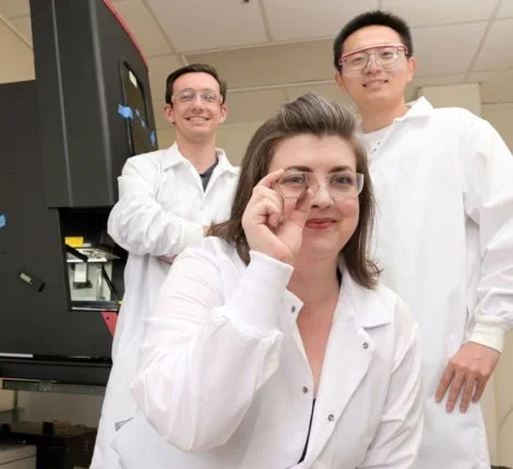 Researchers pose for the camera in white lab coats.