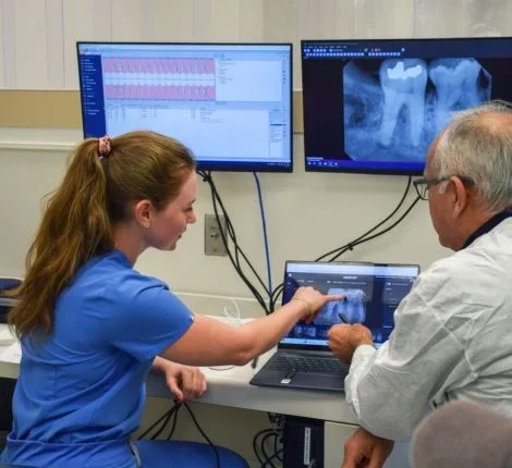 A woman and doctor work together at a computer screen.