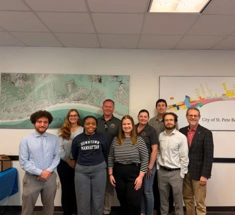 building better communities A group of students standing in front of a wall.